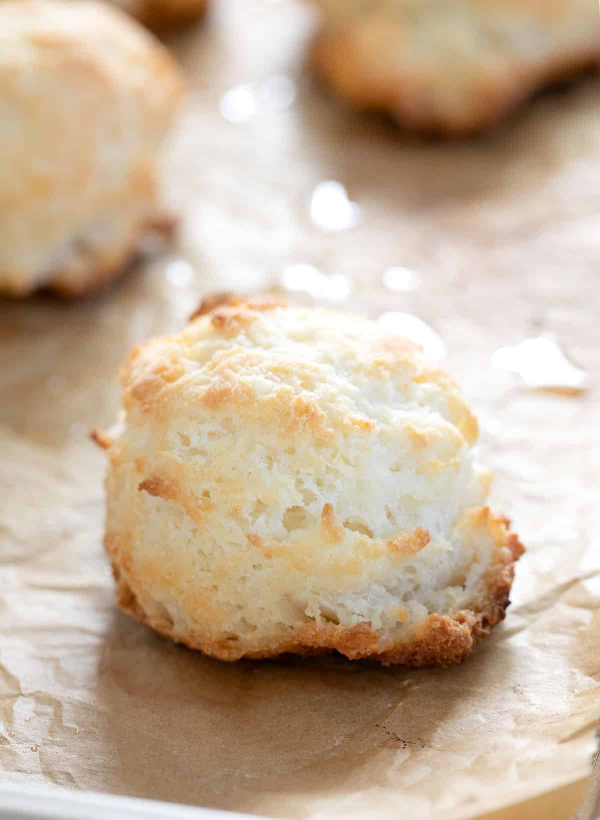 Light tan gluten free biscuits on brown paper with more biscuits in background.