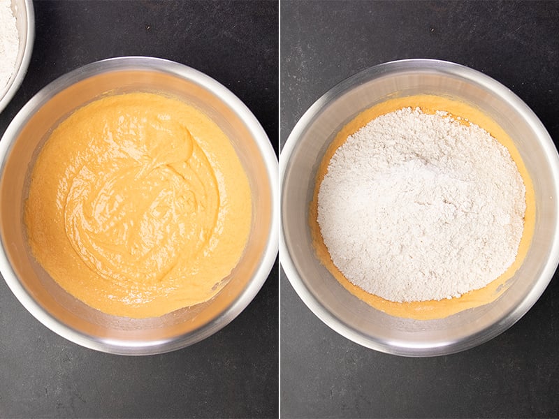 Metal mixing bowl with light orange wet mixture, and with dry ingredients on top