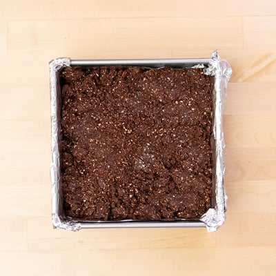 Square metal baking tin with brown protein bar mixture