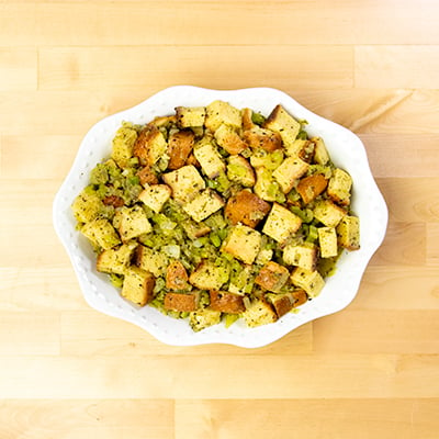 Unbaked gluten free stuffing in white casserole dish