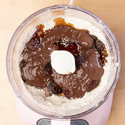 Wet ingredients for protein bars made with medjool dates and chocolate in food processor bowl