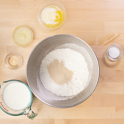 dry ingredients in metal stand mixer mixing bowl with instant yeast on top