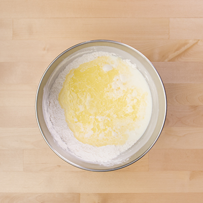 dry ingredients for making bread with wet ingredients in well on top before being mixed in