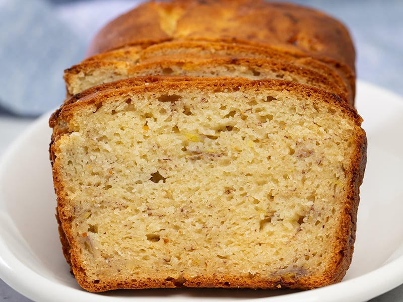 sliced banana bread on white oval platter with blue cloth