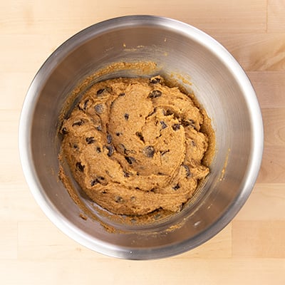 raw mixed dough for almond flour chocolate chip cookies in metal mixing bowl