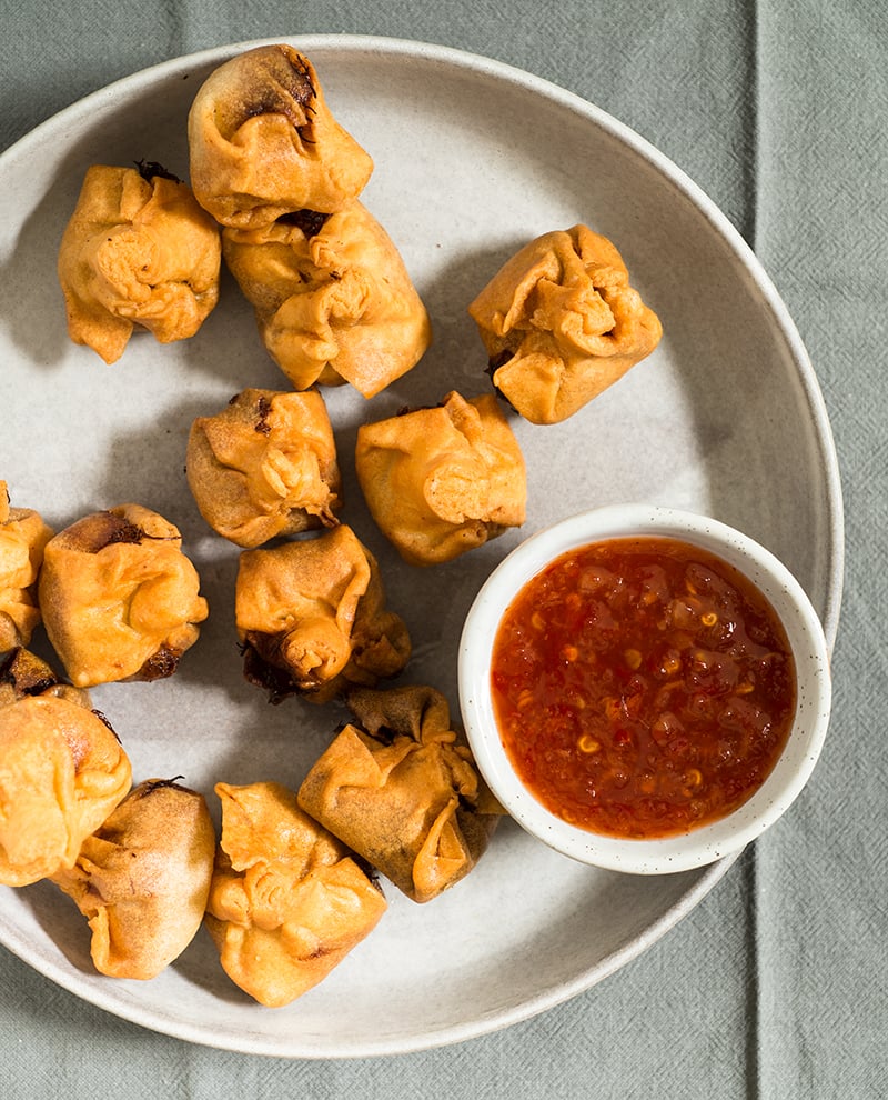 gluten free crab rangoon on plate with dipping sauce