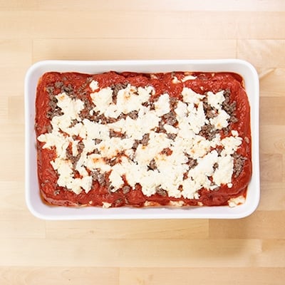 Ground beef with white ricotta cheese on tomato sauce