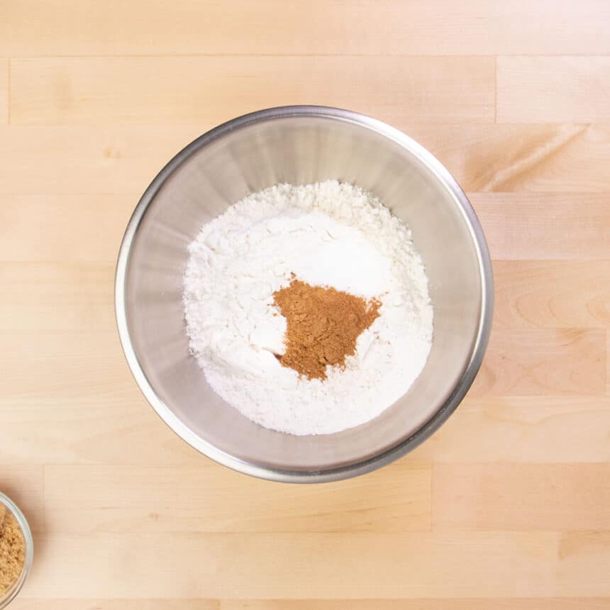 large round metal mixing bowl with flour and brown pumpkin pie spice