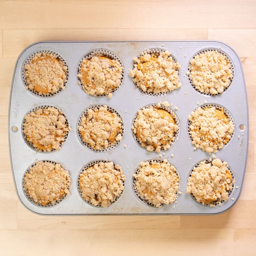 raw muffins in tin with crumble topping