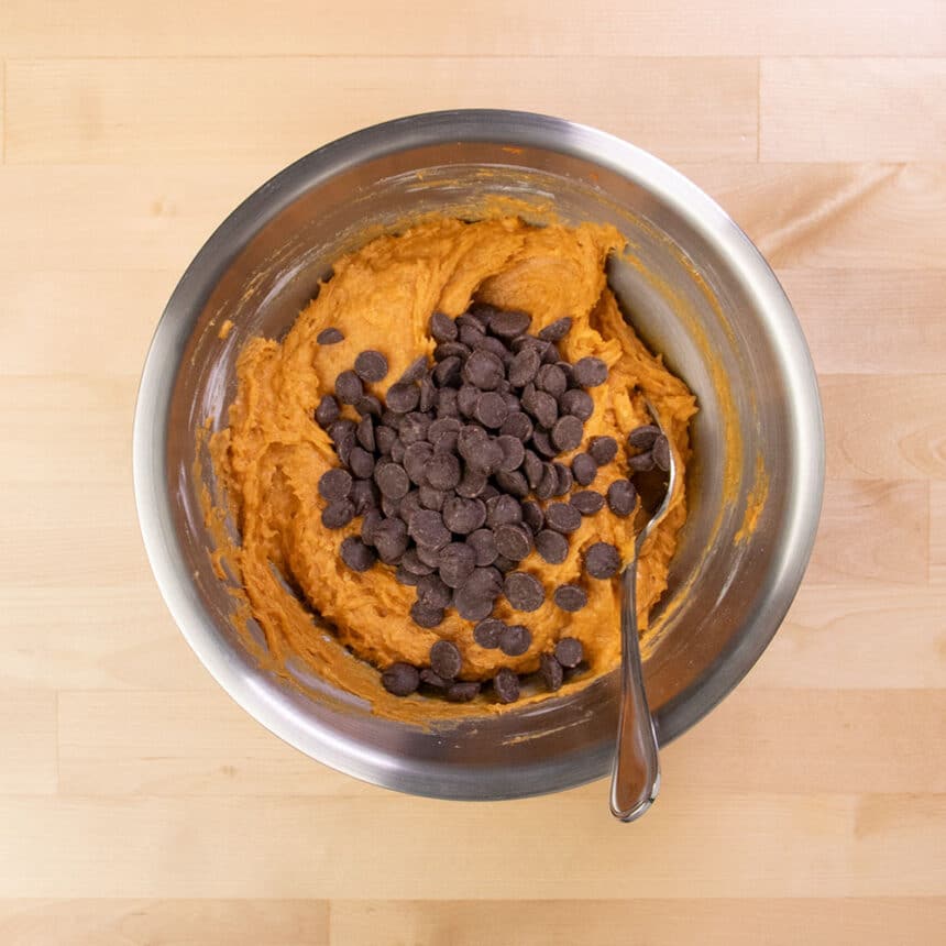 dark chocolate chips on top of light orange batter