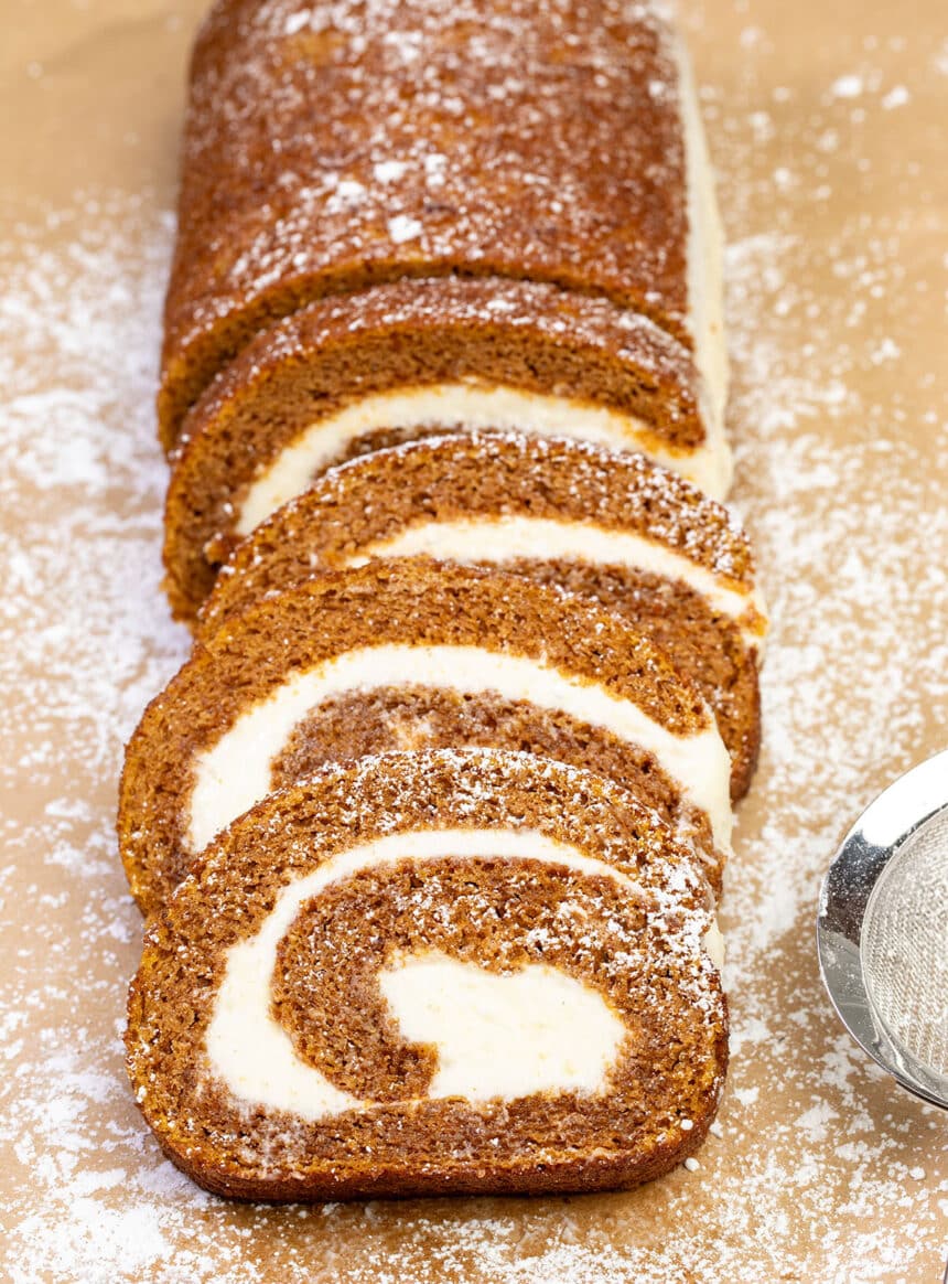 swirl pumpkin cake roll with white filling 4 slices and rest of roll uncut on brown paper