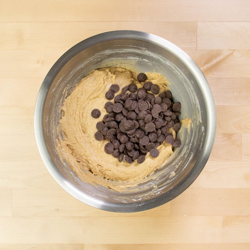 chocolate chips on top of light brown cookie dough