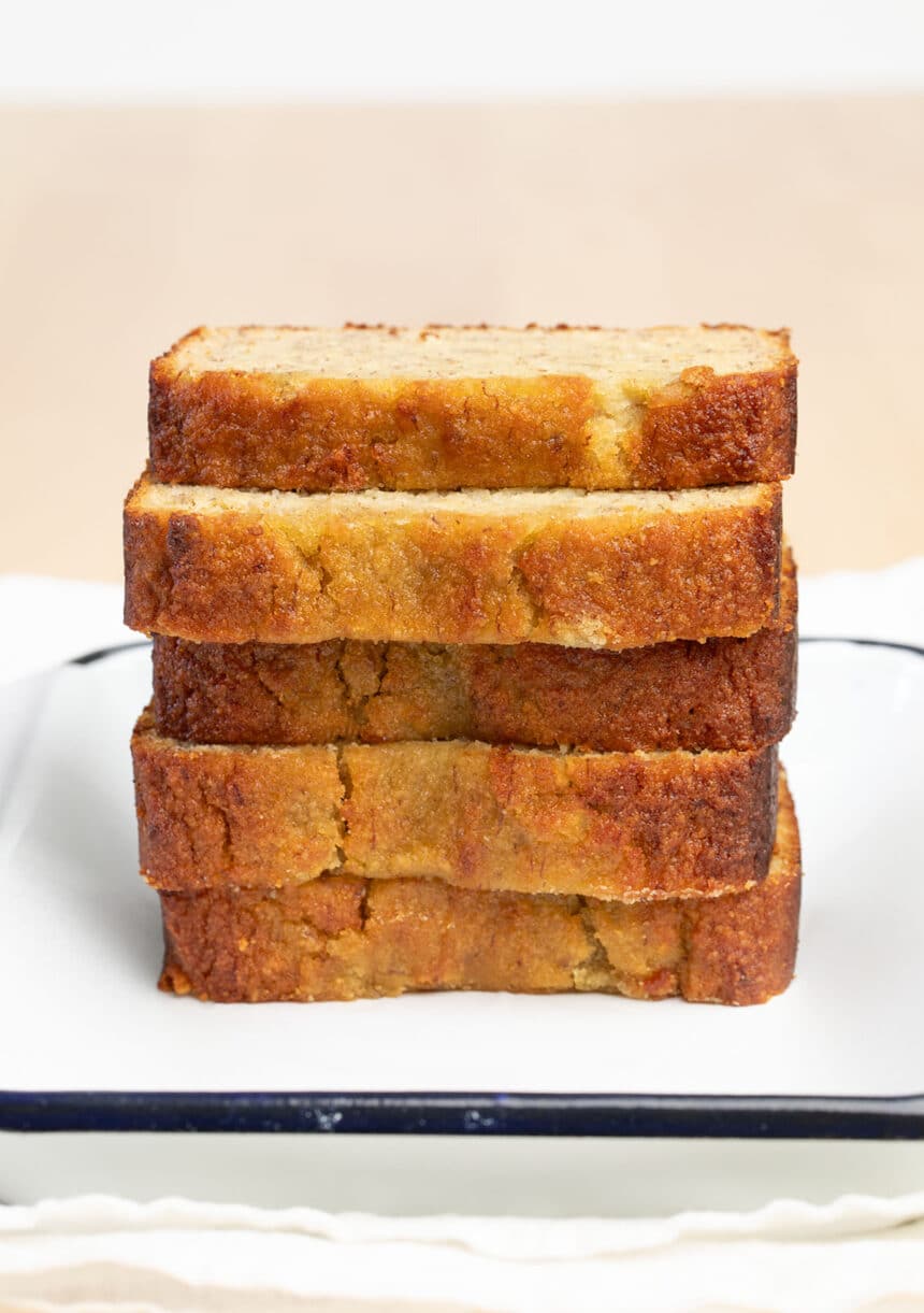 stack of 5 slices of brown almond flour banana bread on white tray with blue border