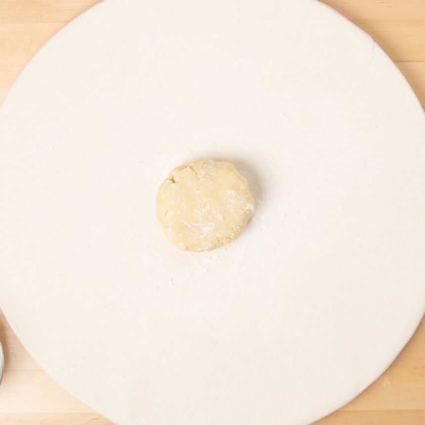 light cloth covered board with round ball of cookie dough in center