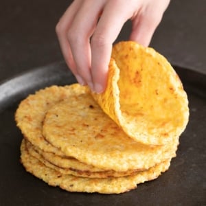 hand folding cauliflower tortilla from stack