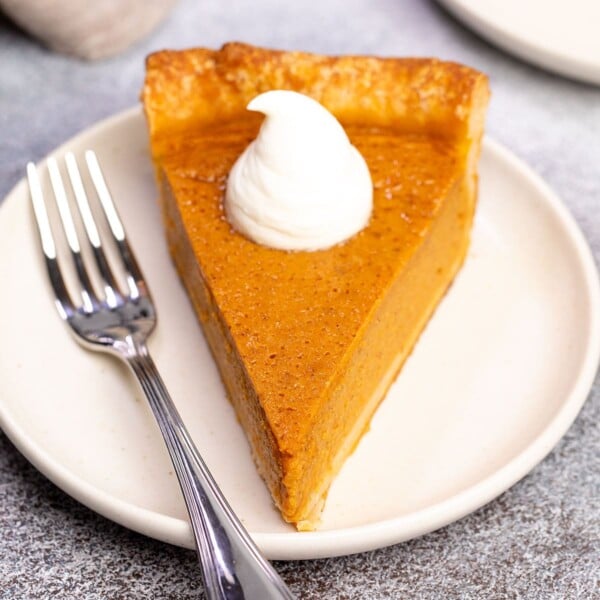 gluten free pumpkin pie on small cream plate with fork