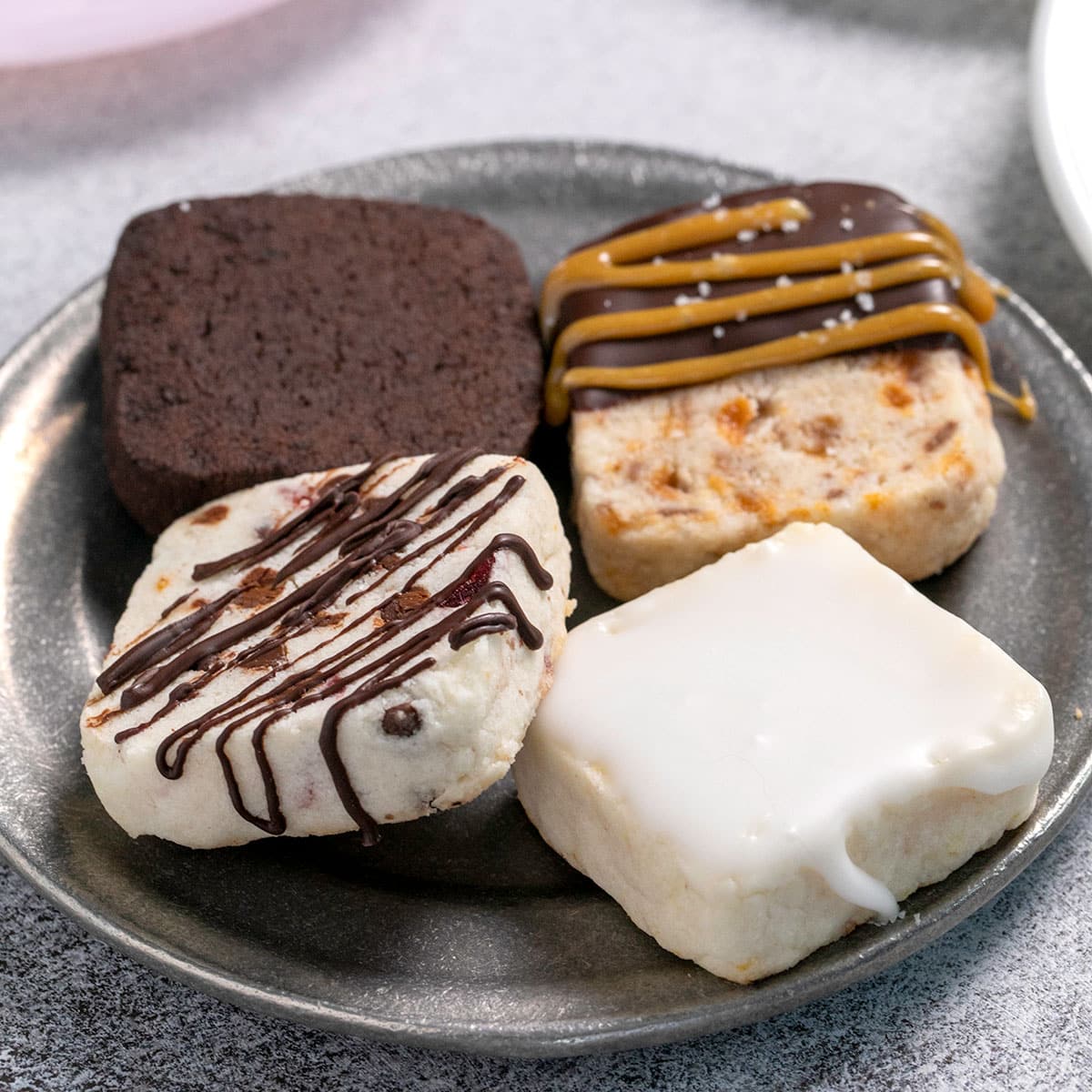 4 varieties of gluten free shortbread cookies on small round plate