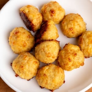 light tan baked chicken meatballs with dark brown spots in white bowl