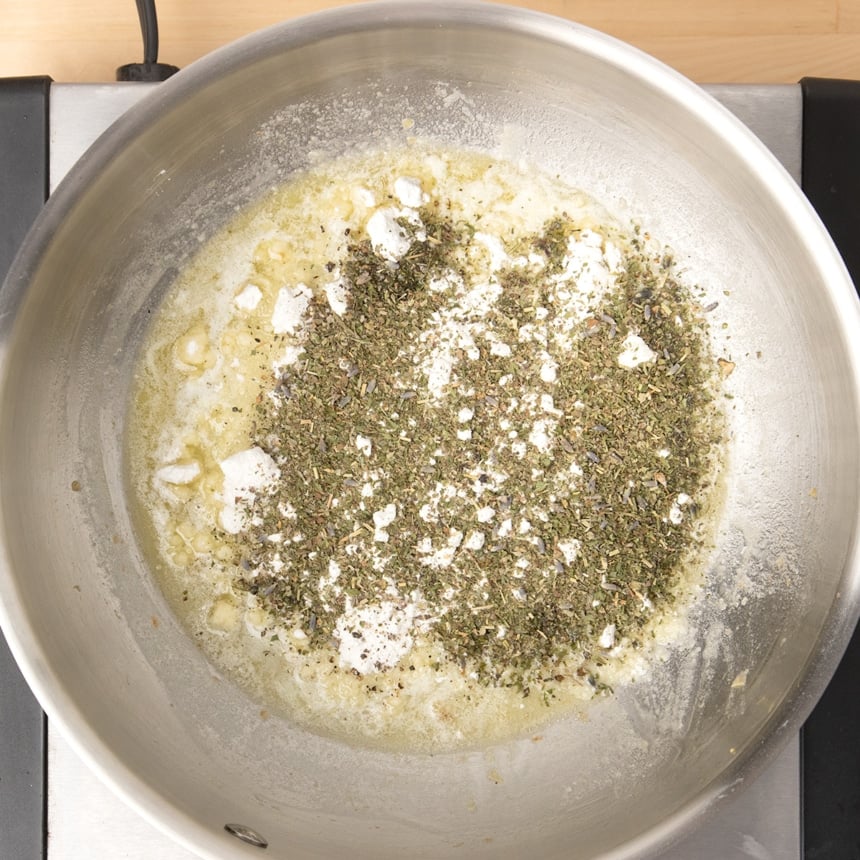 round metal saucepan with layered melted butter, white gluten free flour, dried herbs de provence, salt and papper