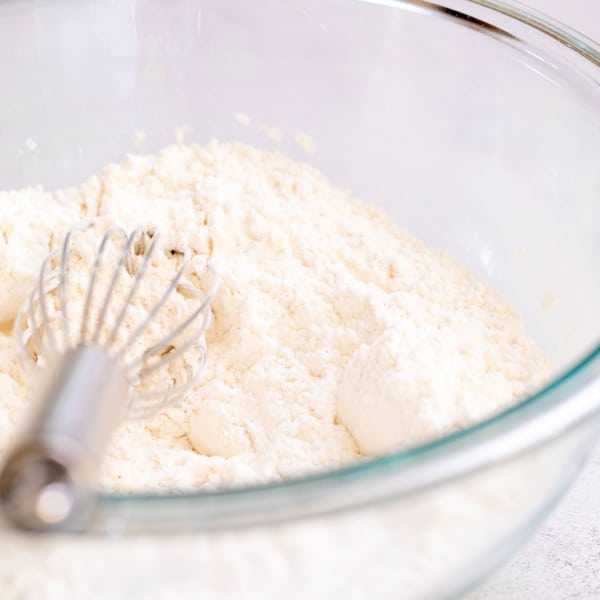 gluten free flour mix in glass bowl with wire whisk