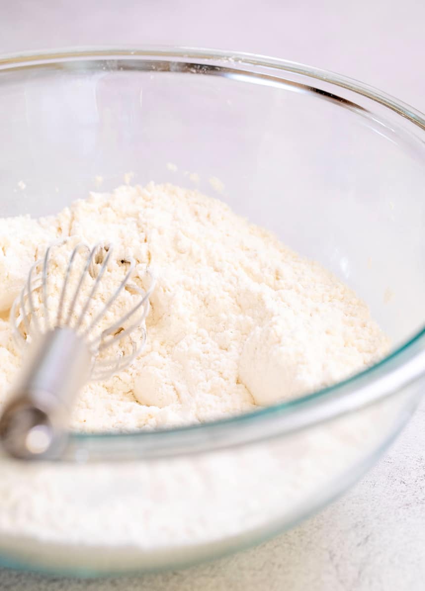 gluten free flour blend in round glass mixing bowl with whisk