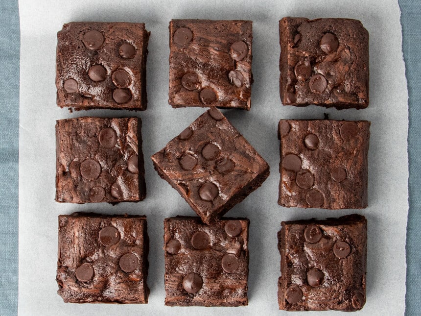 overhead image of 9 oat flour brownies with chocolate chips with center brownie tilted and resting partially on another brownie