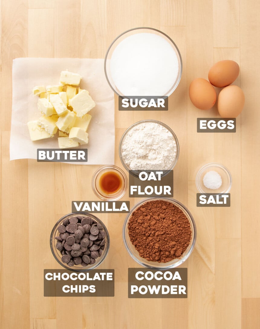 ingredients for oat flour brownies in small round bowls with names of ingredients