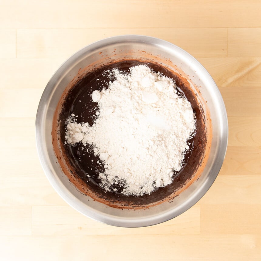 very light brown oat flour on top of dark brown liquid in mixing bowl