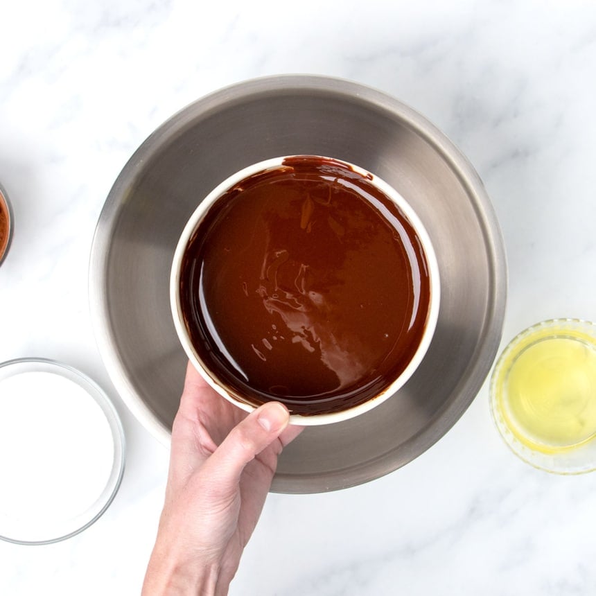 hand holding melted chocolate and butter in small bowl