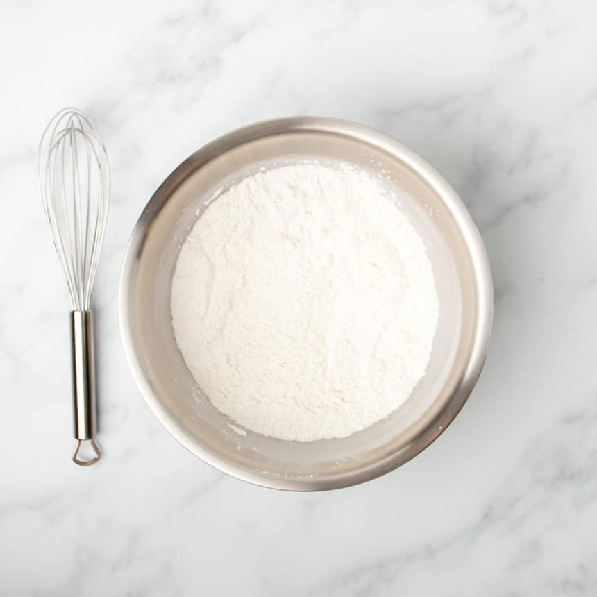 whisked white dry ingredients in same mixing bowl with wire whisk next to the bowl