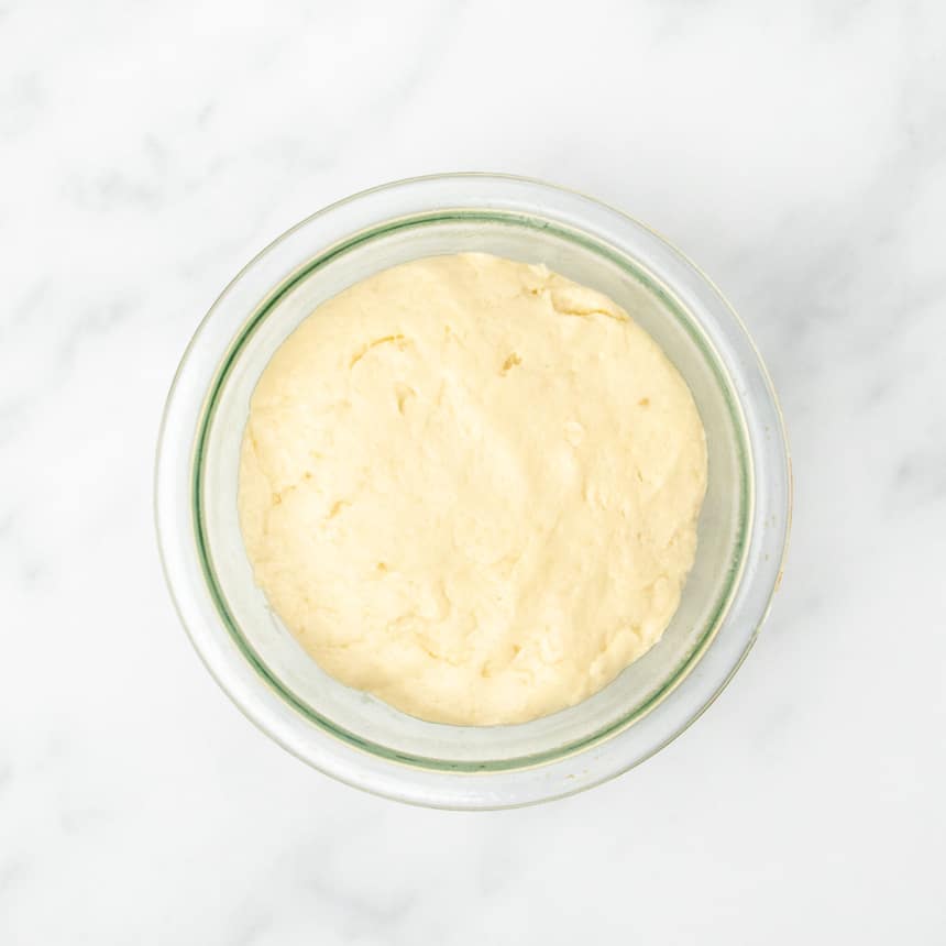 smooth light yellow unrisen raw bread dough in greased 1 quart glass pyrex bowl