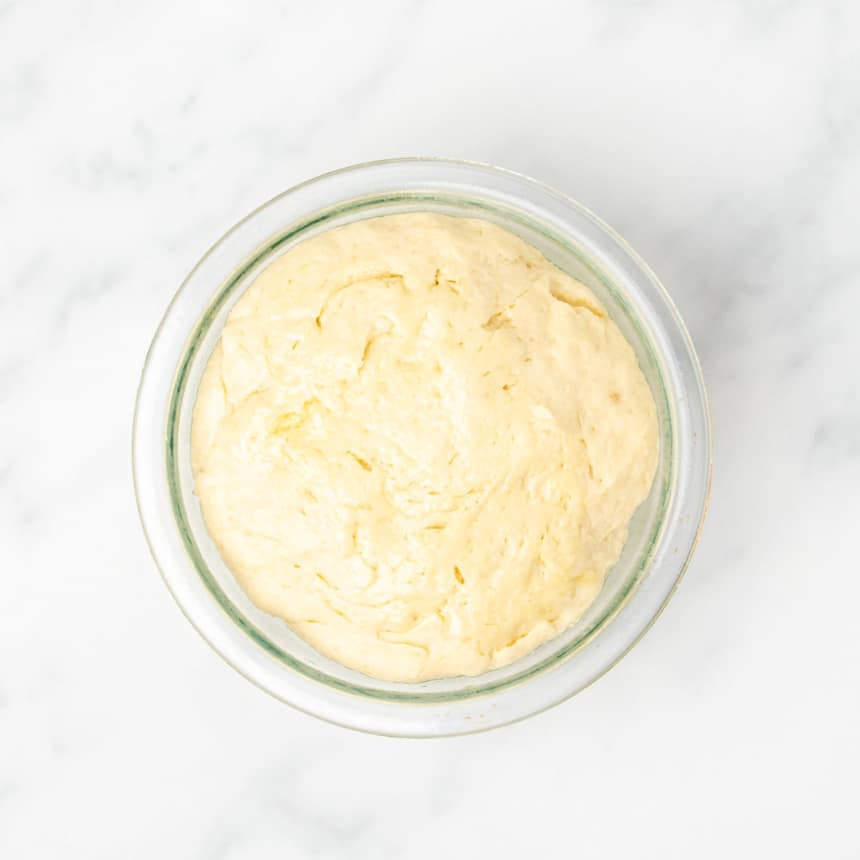 same light yellow dough in pyrex bowl now risen to about 50 percent larger in volume than before