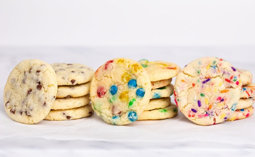 3 tacks of 4 cookies with one cookie on its side leaning against rest of stack, all with different mix-ins