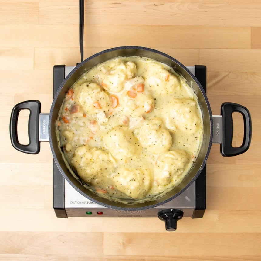 finished gluten free chicken and dumplings soup with 8 or 9 dumplings in black pot