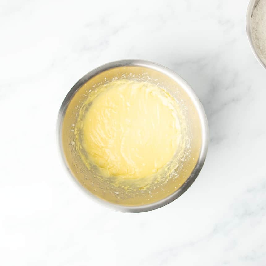 Light yellow batter in large round metal mixing bowl