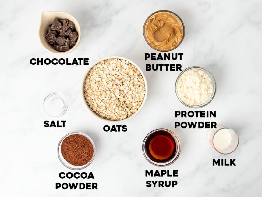 homemade protein bars overhead image of ingredients for peanut butter and cocoa powder version in small bowls with identifying words