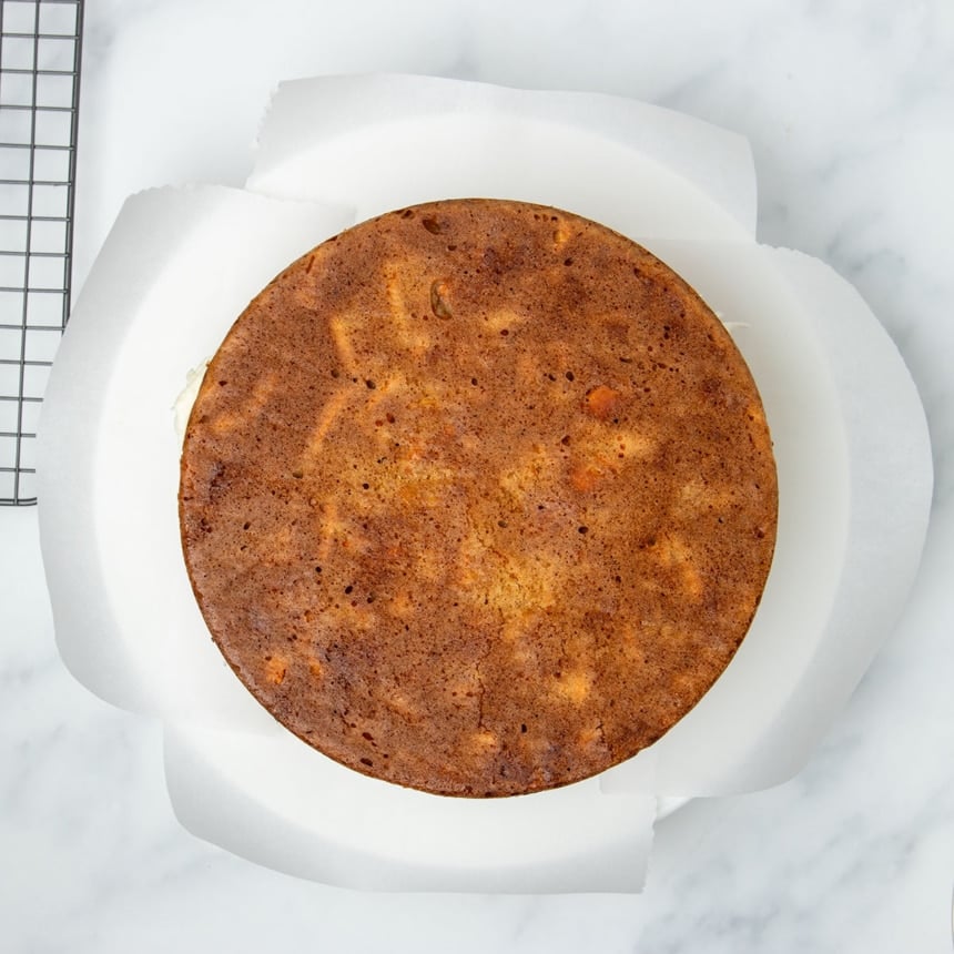 second baked brown carrot cake on top of icing in center