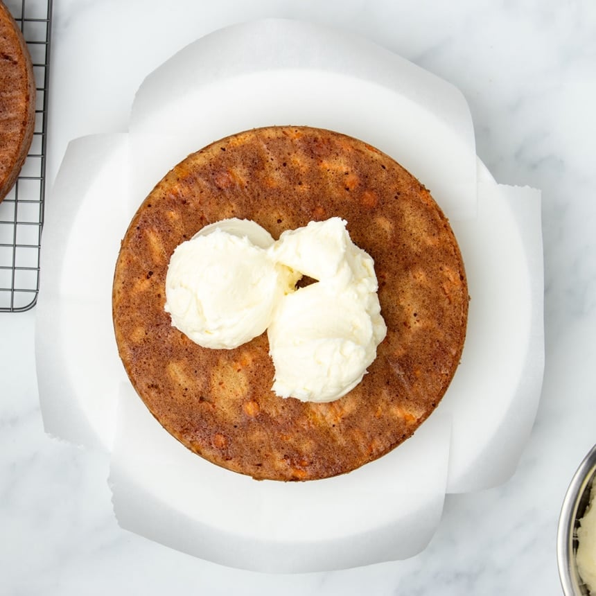 3 scoops of white cream cheese icing in center of overturned baked brown cake