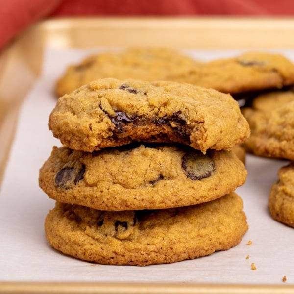 stack of 3 gluten free pumpkin chocolate chip cookies with bite taken from top one