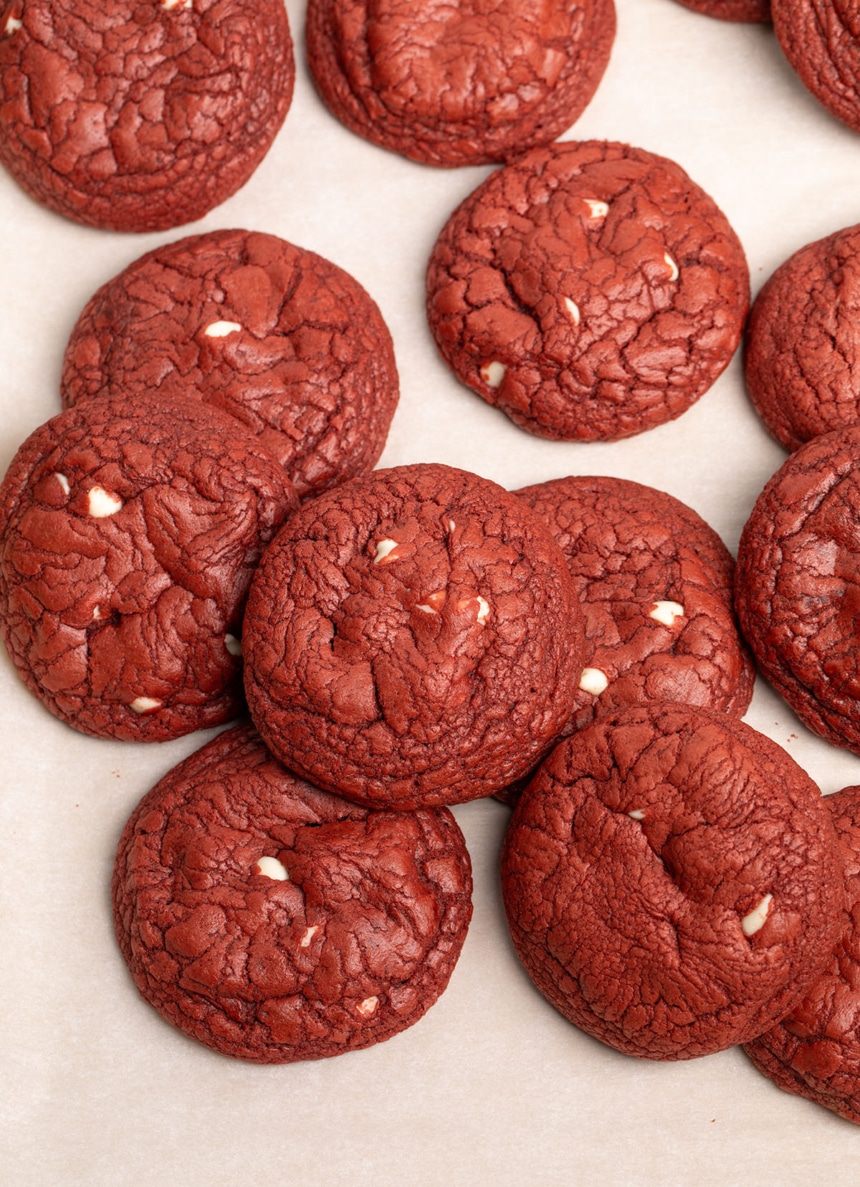 pile of gluten free red velvet cookies with white chocolate chips on white paper