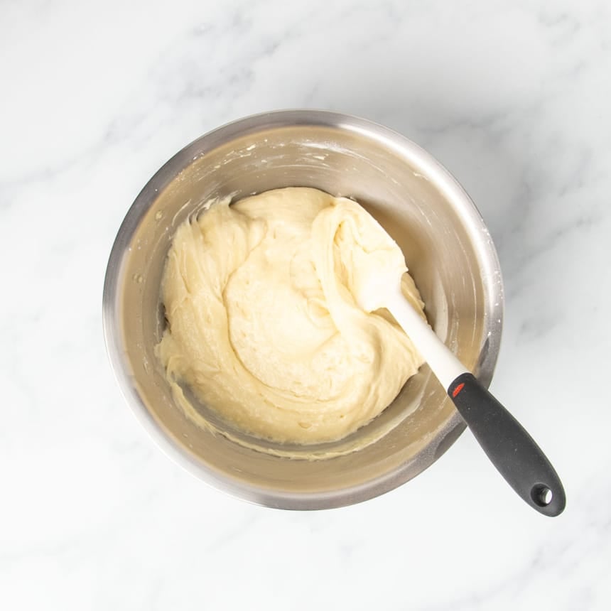 soft, thick light yellow gluten free vanilla cupcake batter with swirl from being mixed with white spatula with black handle