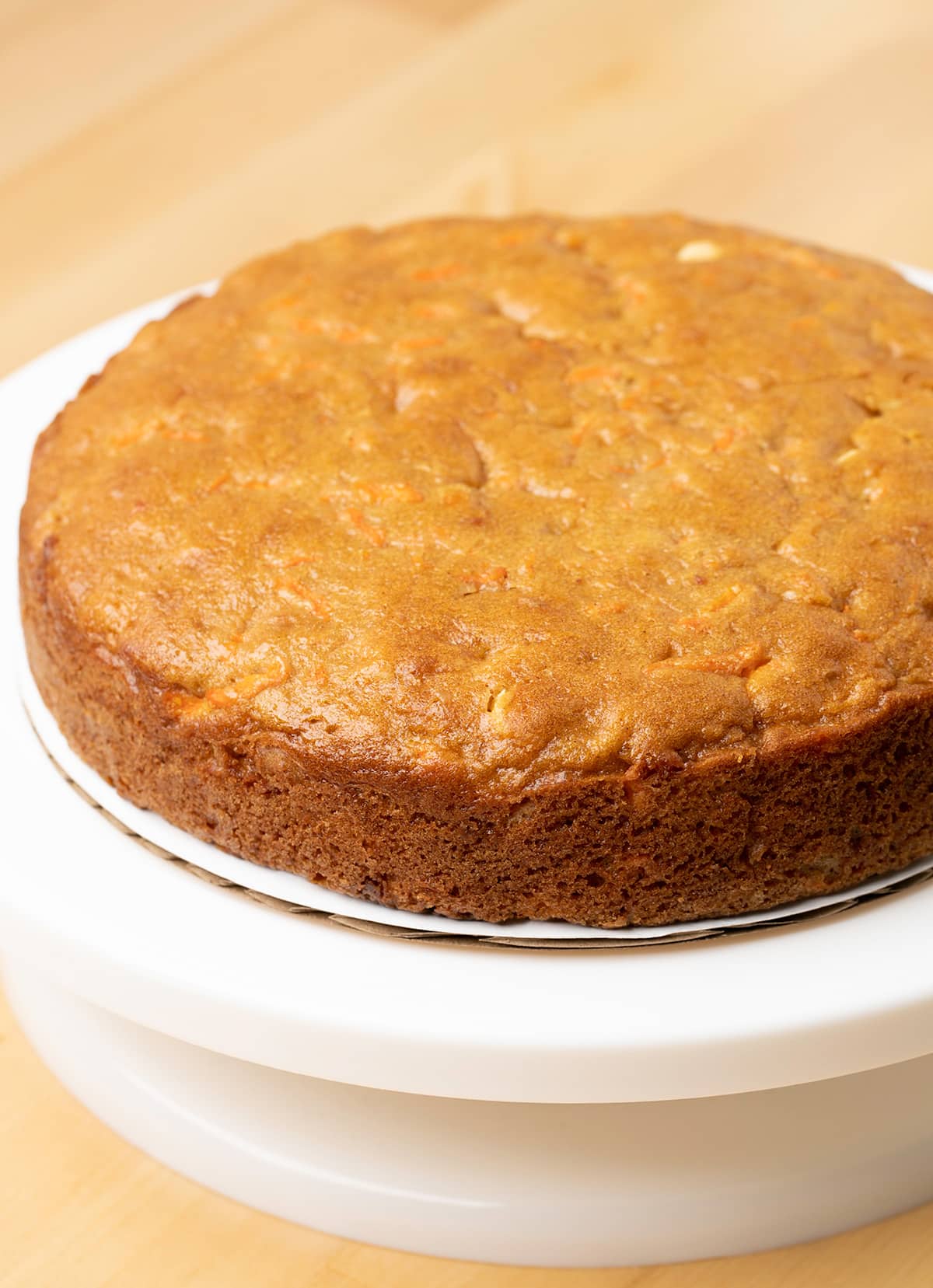 Single layer baked gluten free carrot cake on white cake turner