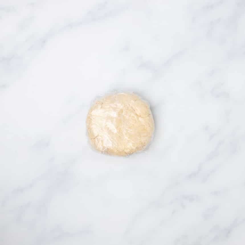 plastic wrapped tightly around cracker dough disk