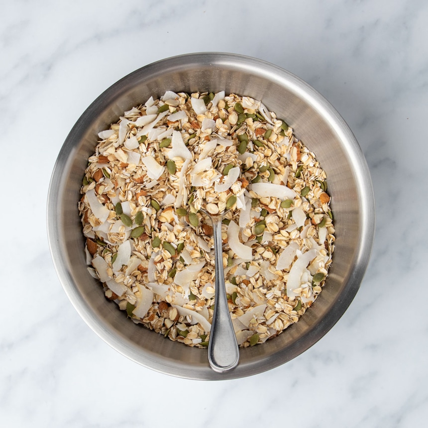 same mixing bowl with those same ingredients mixed with large metal mixing spoon