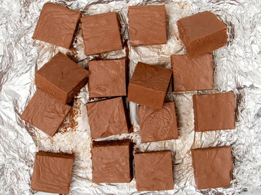 16 squares of marshmallow cream fudge on spread out piece of aluminum foil, with some squares overlapping one another