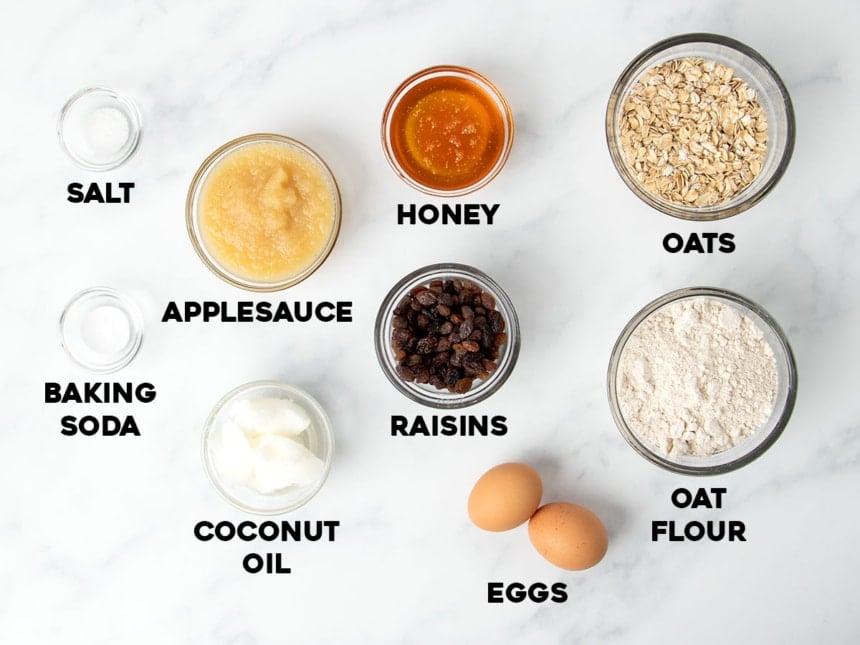 ingredients for oatmeal breakfast cookies in small glass bowls with black lettering indicating the name of each ingredient