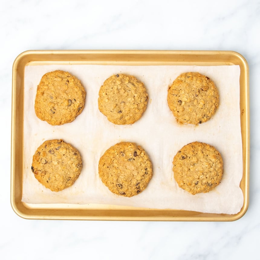 same baking sheet with cookies baked in oven into medium brown color with darker brown edges