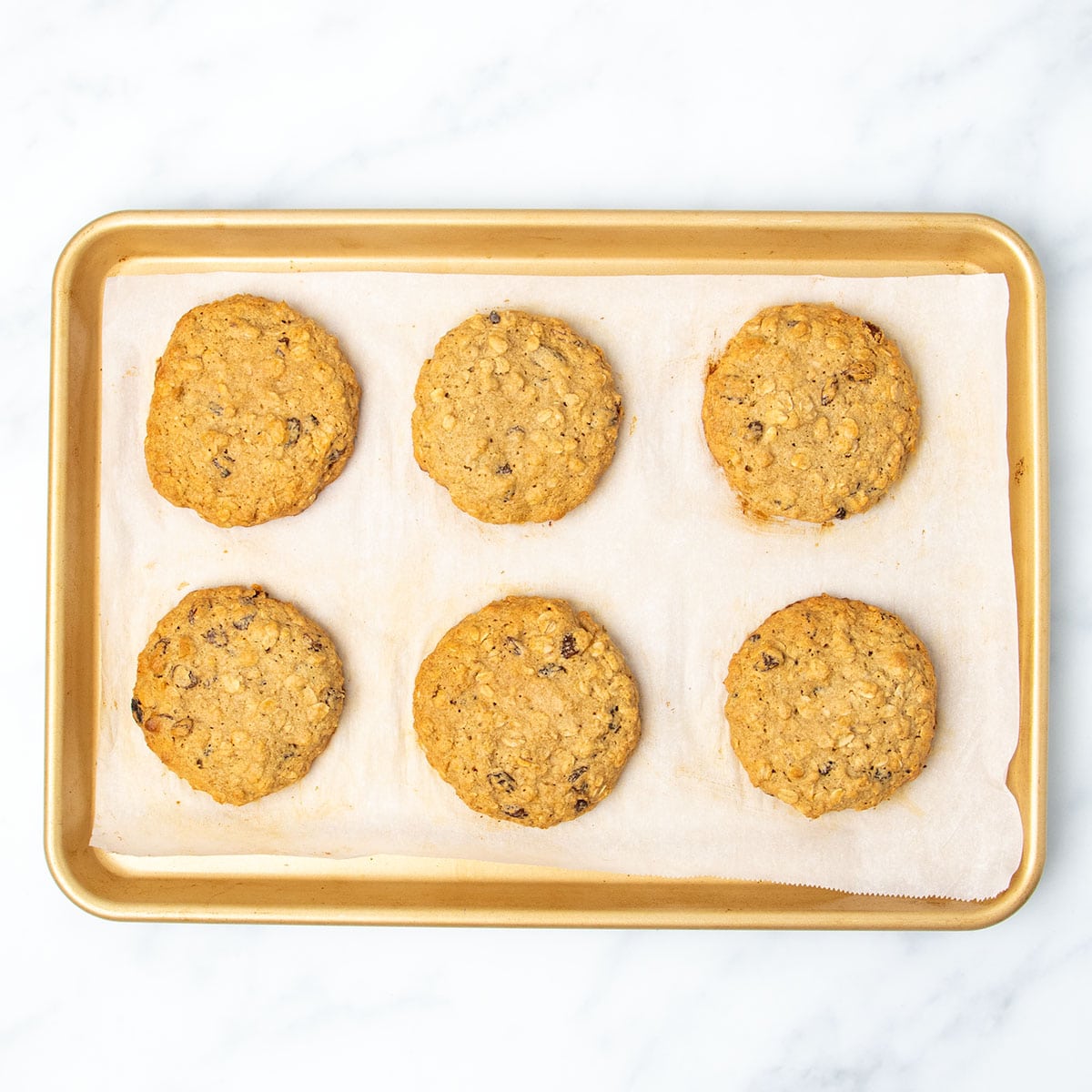 same baking sheet with cookies baked in oven into medium brown color with darker brown edges