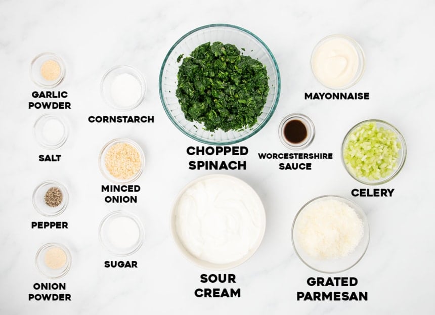 overhead image of ingredients for gluten free spinach dip in small bowls with words of ingredients in black type