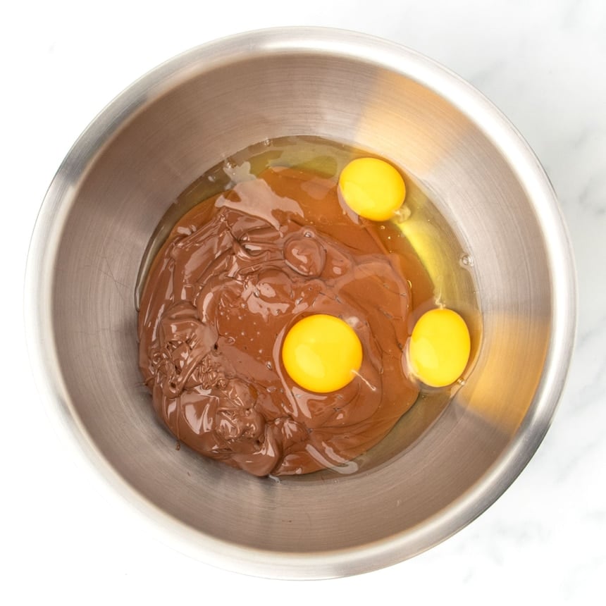 same bowl, with 3 raw eggs added (yellow yolks visible)